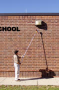 Using a Gotcha Sprayer to spray a wasp nest at school